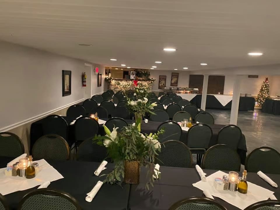 A large dining room set for an event with long tables, chairs, and floral centerpieces.