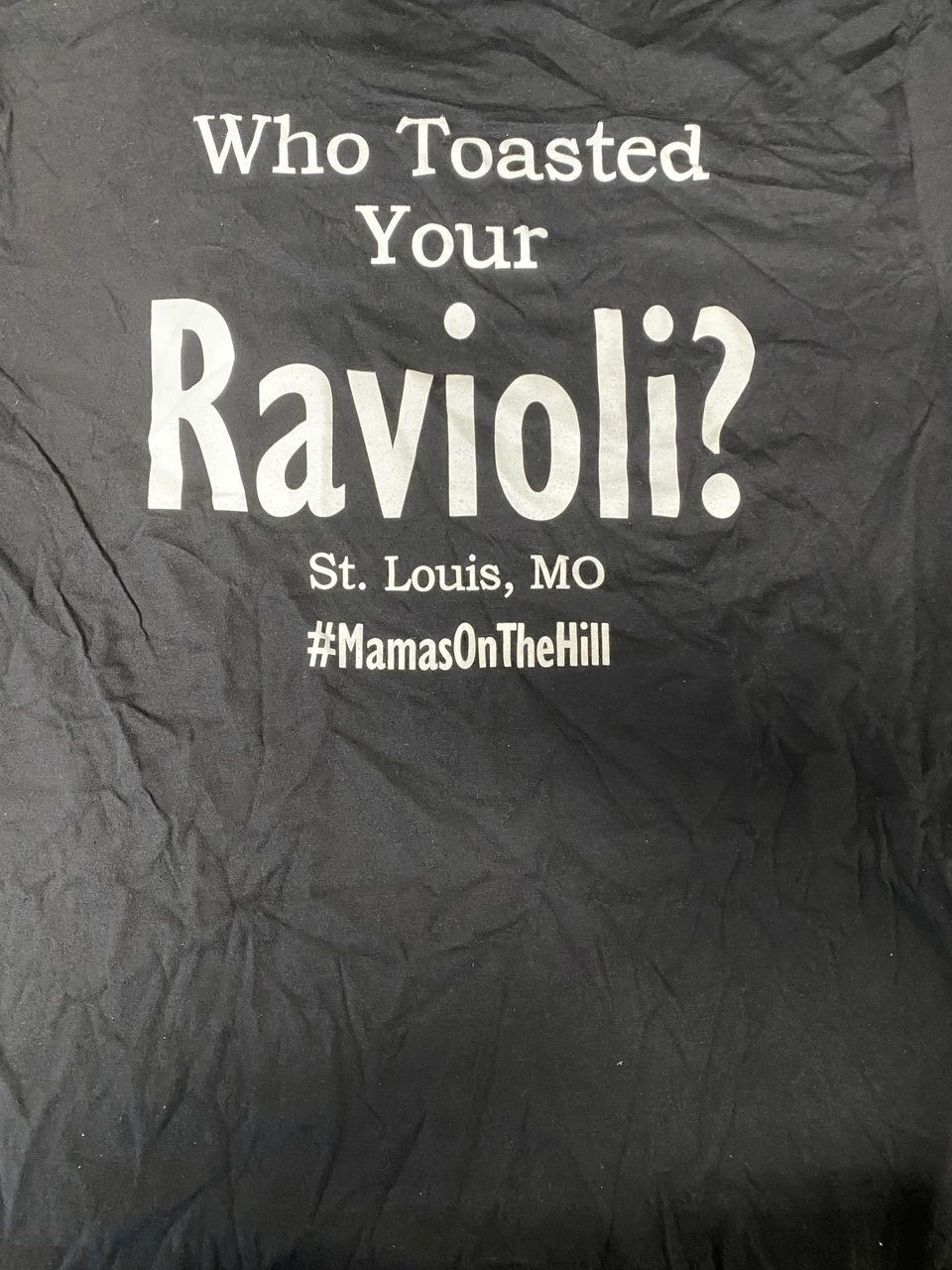 Black t-shirt with white text: "Who Toasted Your Ravioli? St. Louis, MO #MamasOnTheHill"