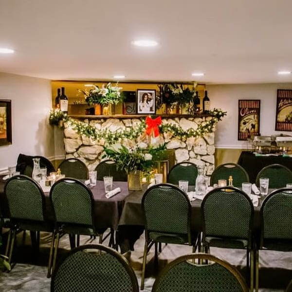 A dining room set for a holiday party with a long table, chairs, and a buffet.