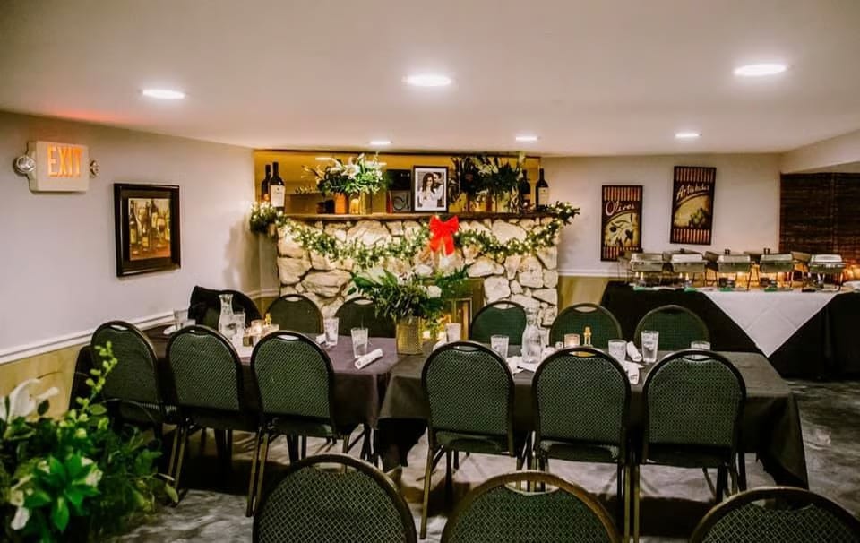 A dining room set for a holiday party with a long table, chairs, and a buffet.
